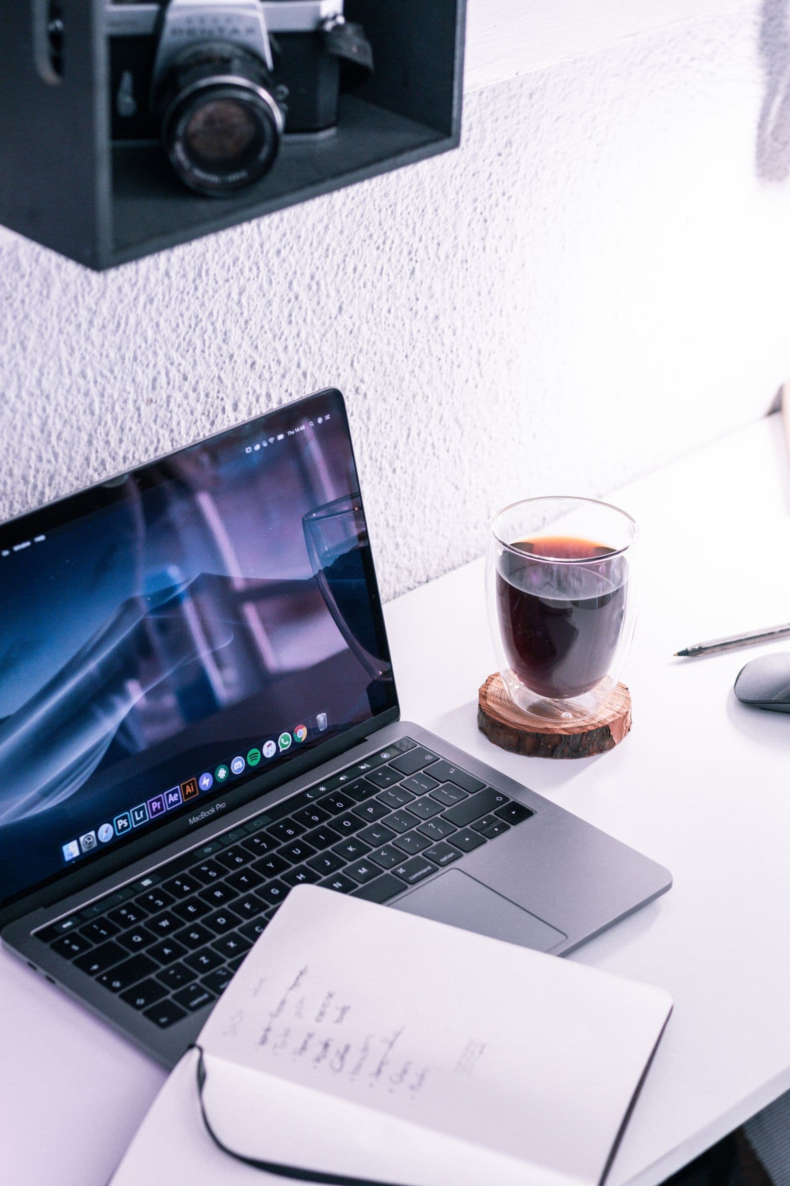 Laptop, coffee and notebook on a tidy desk