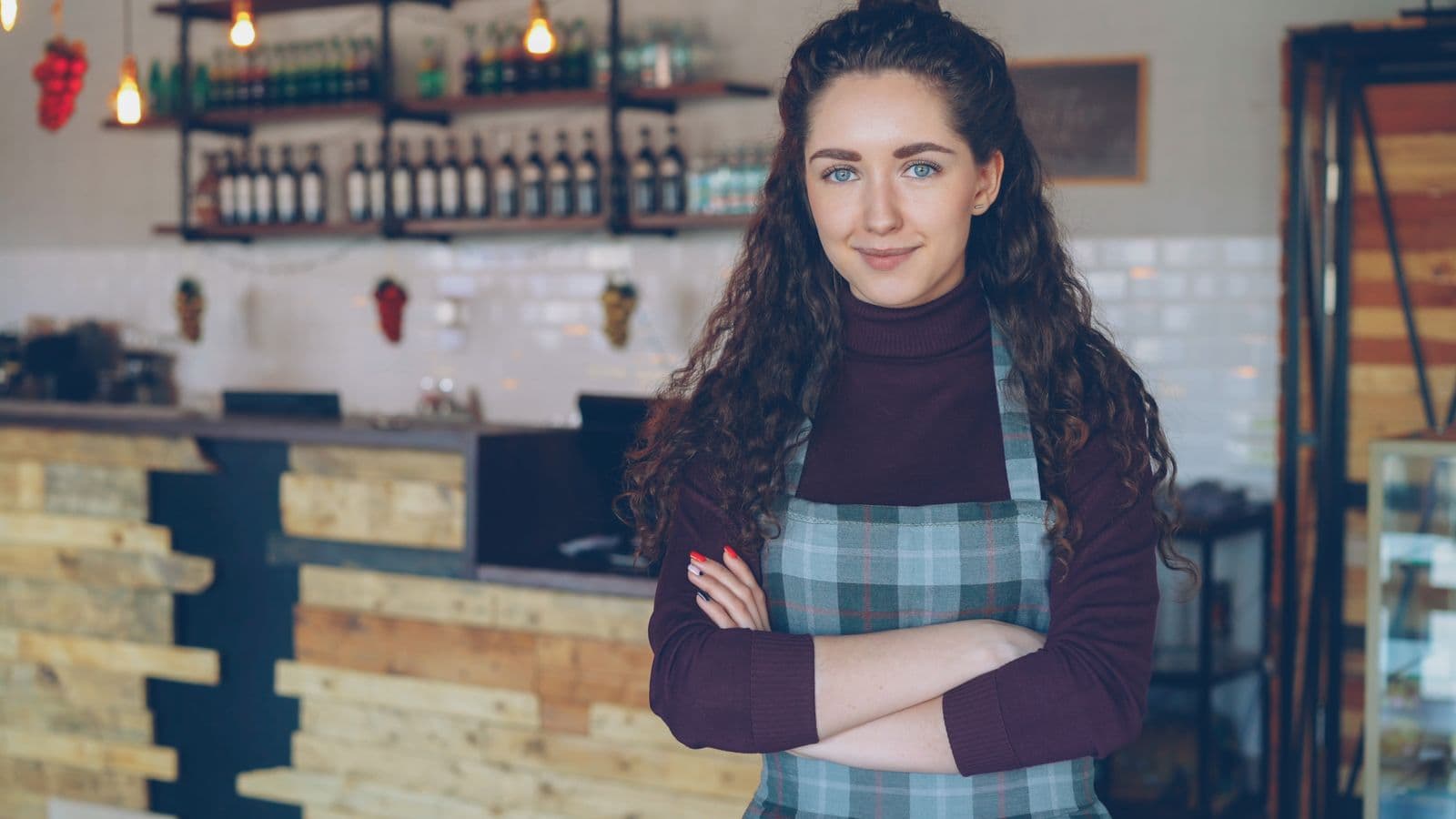 Café owner standing confidently behind the counter of a coffee shop