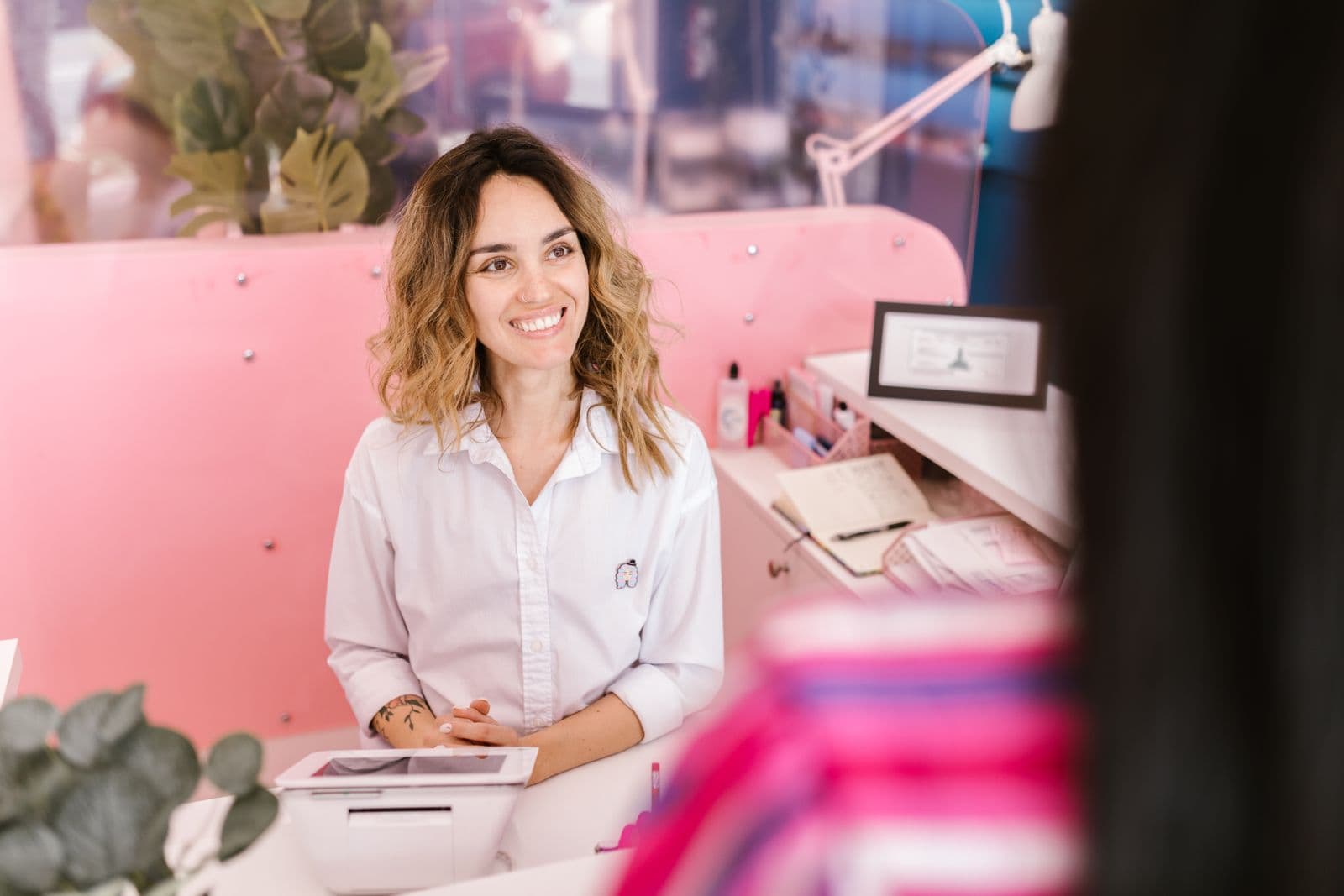 Friendly receptionist welcoming a client at a front desk